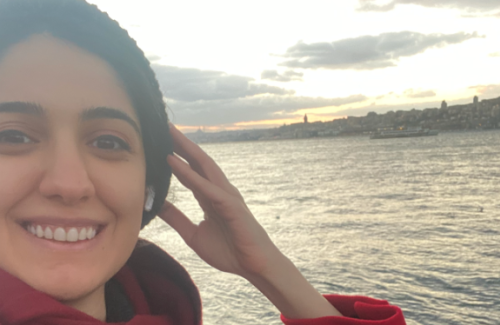 Humeyra smiling with the sea in the background.